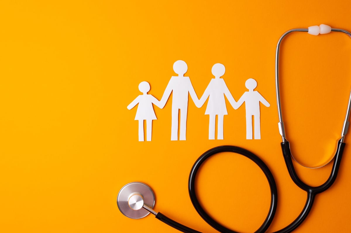 Paper family cutout with stethoscope — representing family-centered healthcare
